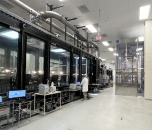 EPA Aerosol Test Facility with large test chambers, monitoring equipment, and a researcher.